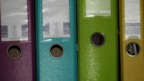 Neatly labelled office binders on a shelf