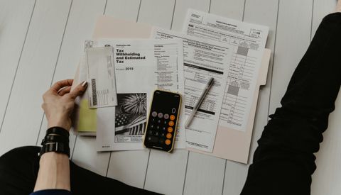 Financial paperwork beside a calculator and pen